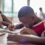 boy writing on printer paper near girl