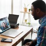man in blue and white plaid dress shirt using macbook pro
