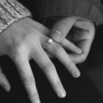 woman wearing wedding ring with man holding hand