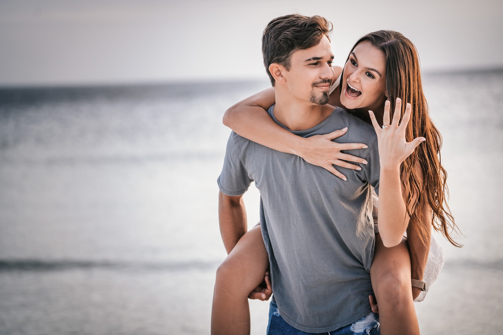 man in white crew neck t-shirt hugging woman in blue denim shorts