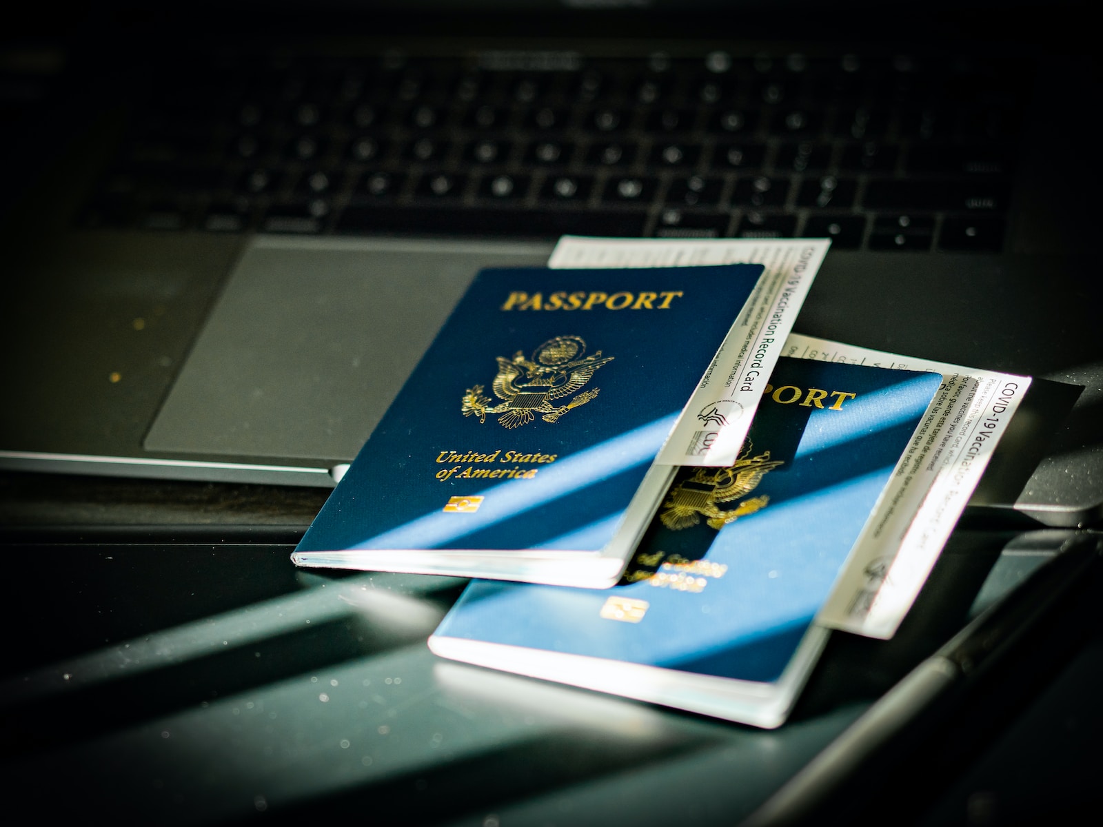 a passport sitting on top of a computer keyboard