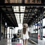 woman holding pink luggage